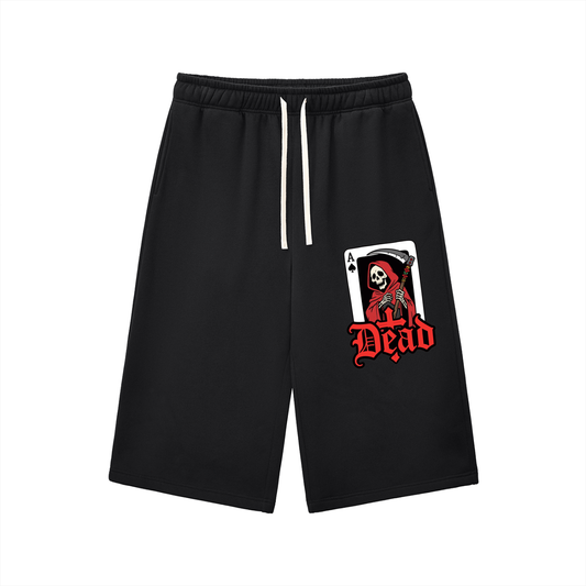 Black three-quarter sweatpants with elastic waistband and drawstring, front graphic patch