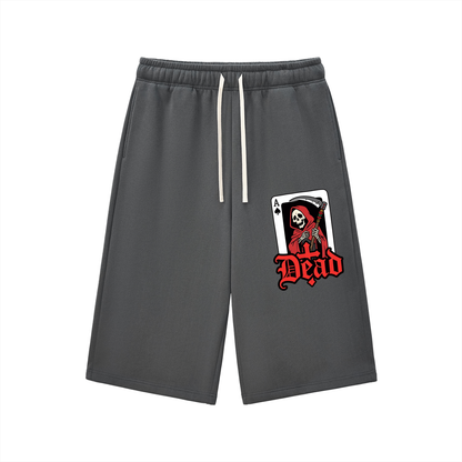 Charcoal gray three-quarter sweatpants with elastic waistband and drawstring, front graphic patch