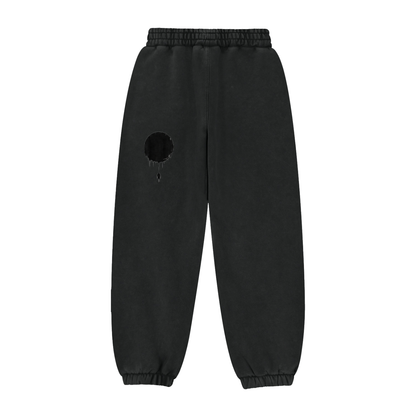 Black sweatpants with elastic waistband and cuffs, dark eclipse patch on leg with small drips