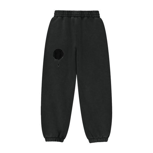 Black sweatpants with elastic waistband and cuffs, dark eclipse patch on leg with small drips