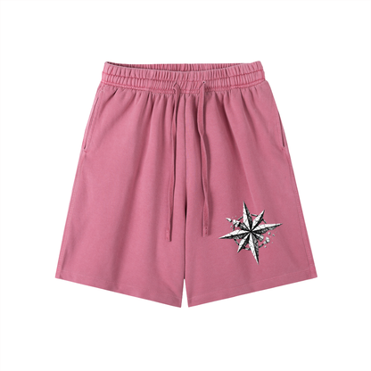 Pink vintage-wash cotton shorts with elastic waistband, drawstring, and side star graphic.