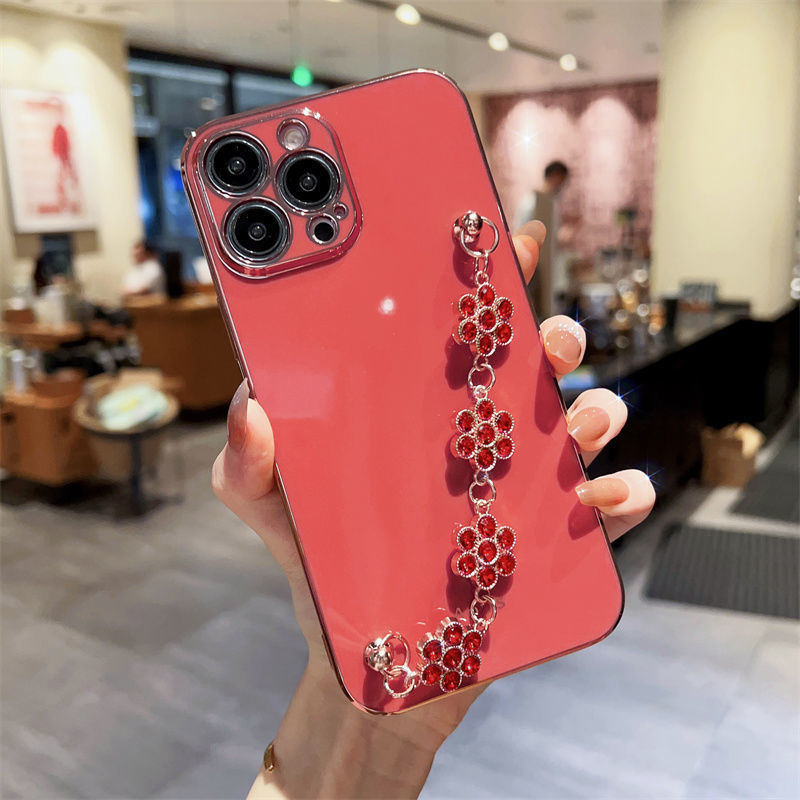 Red phone case with red rhinestone chain bracelet and gold-toned connector rings