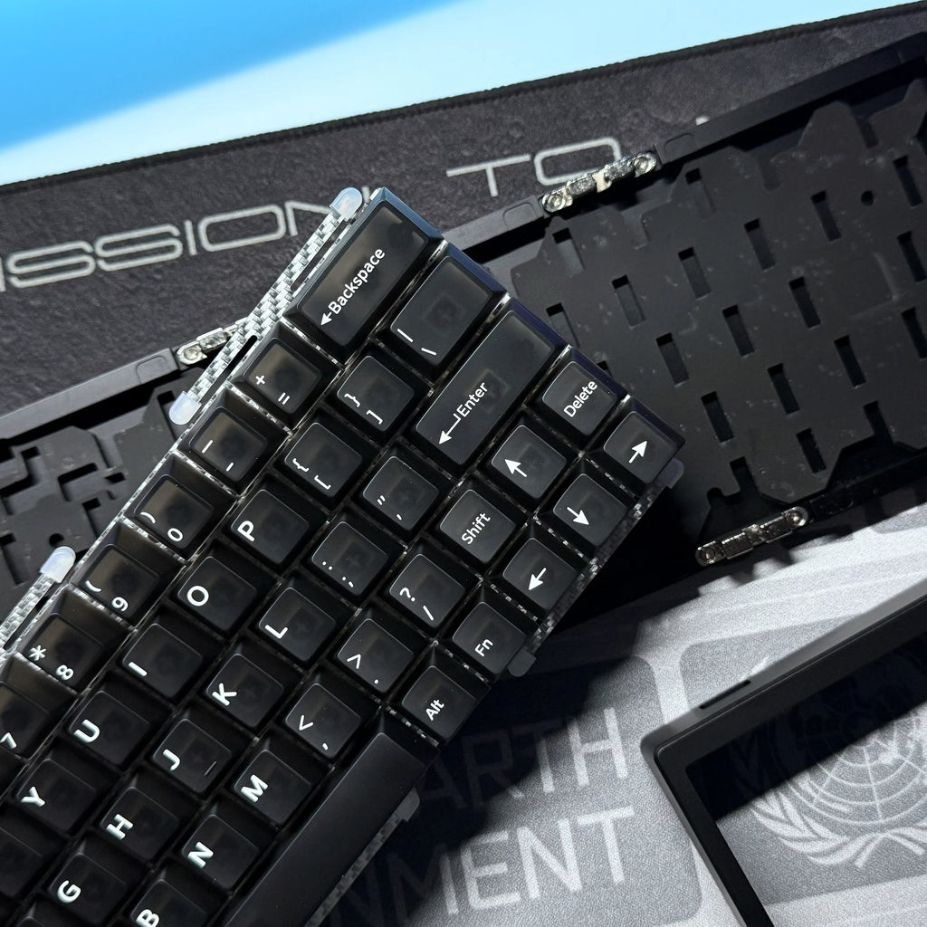 Black keyboard PCB with keycaps and metal switch parts, close-up view