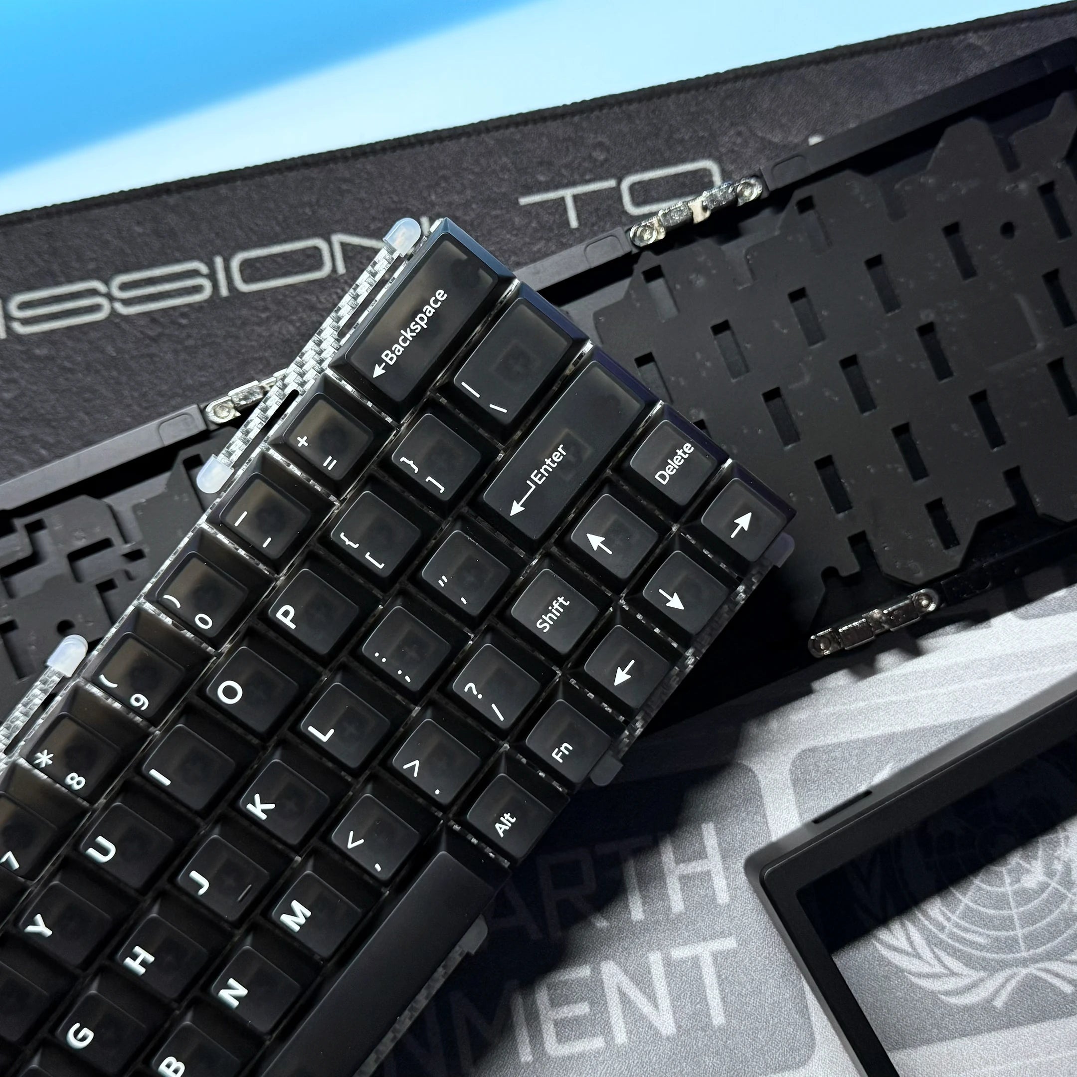 Black keyboard PCB with keycaps and metal switch parts, close-up view