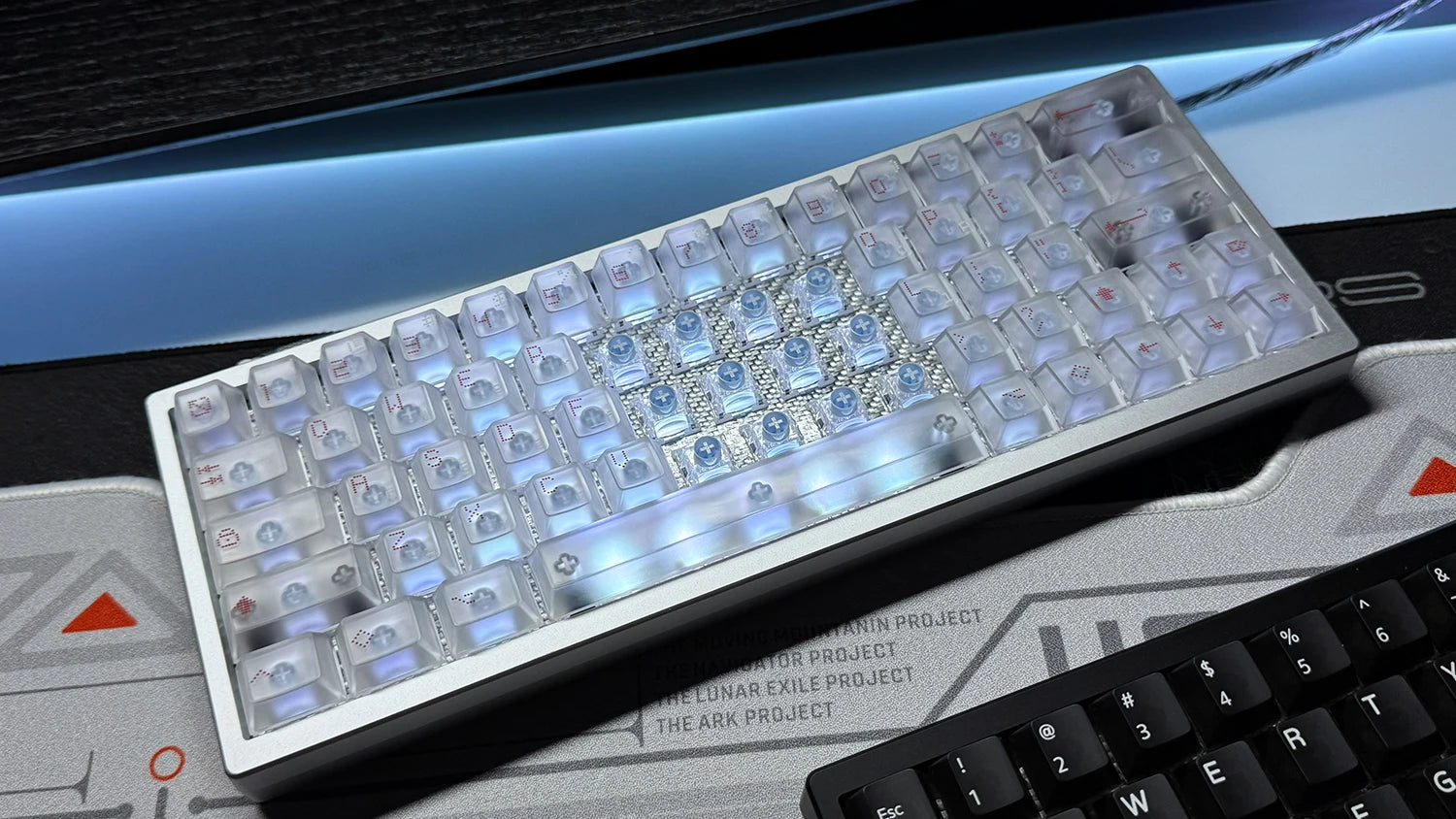 Mechanical keyboard with translucent keycaps on a white plate and dark base