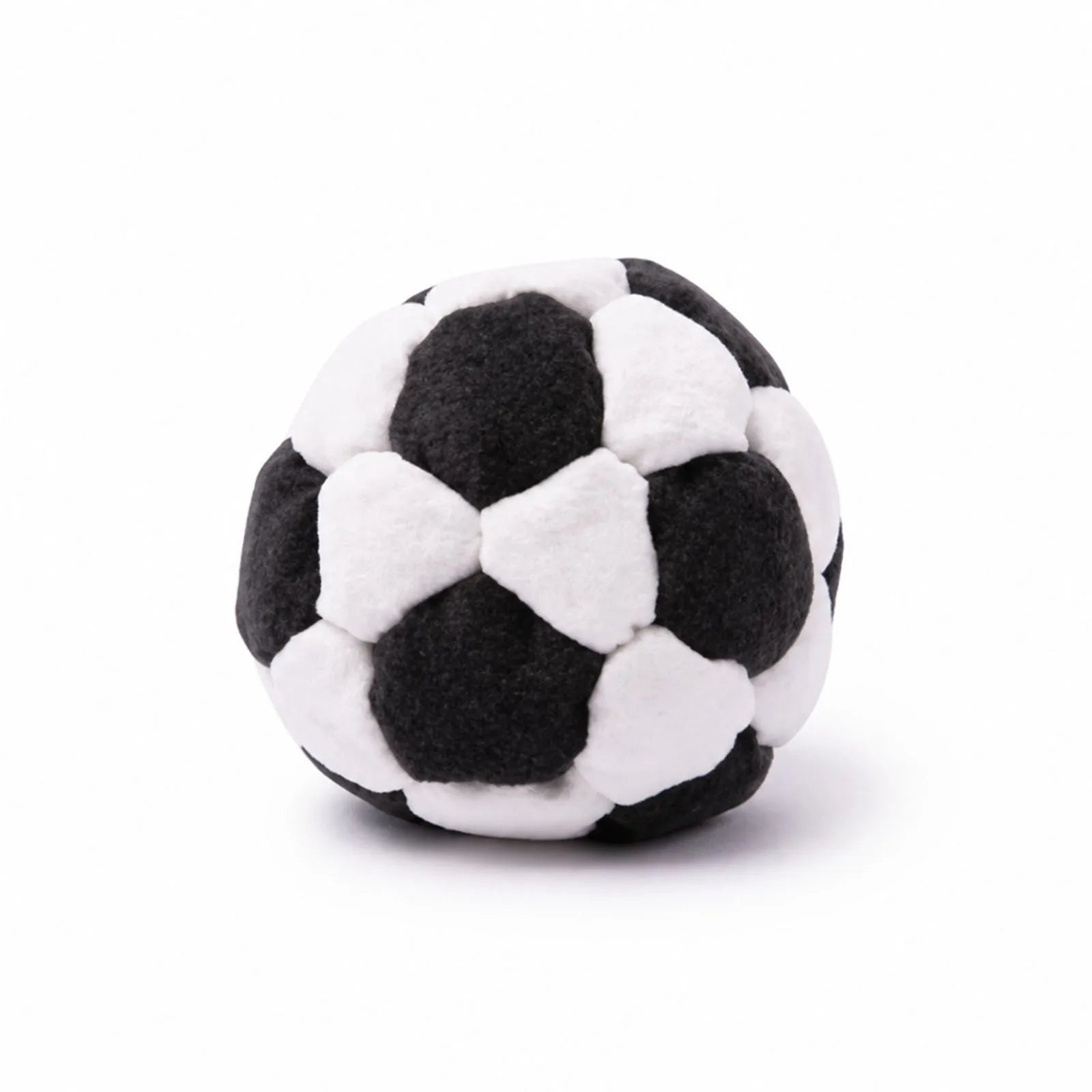 Black and white plush footbag ball with padded patch panels, soft fuzzy texture.