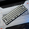 White keyboard PCB kit with cream keycaps and visible mechanical switches
