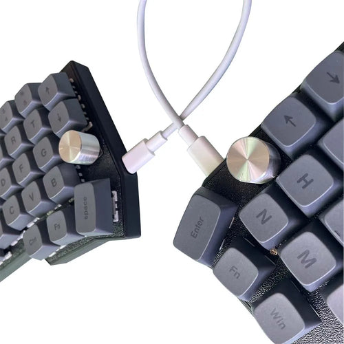 Close-up of Corne 4x6 split keyboard: rotary knobs and key clusters with cable