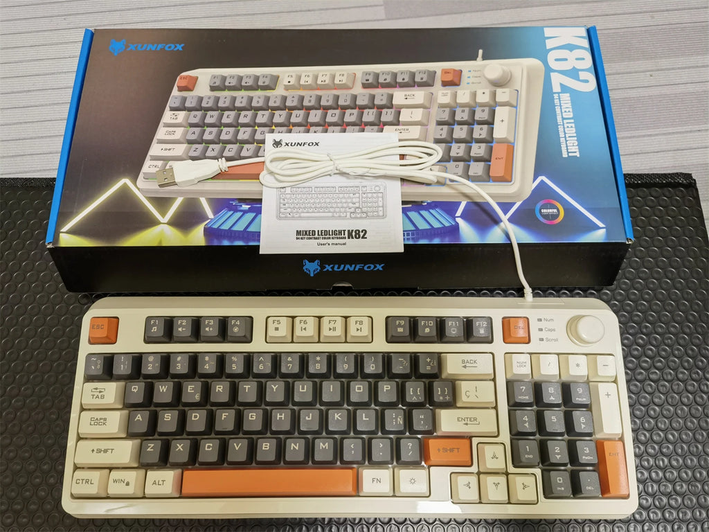 Wired keyboard with cream keycaps, black keys, and orange trim across the layout