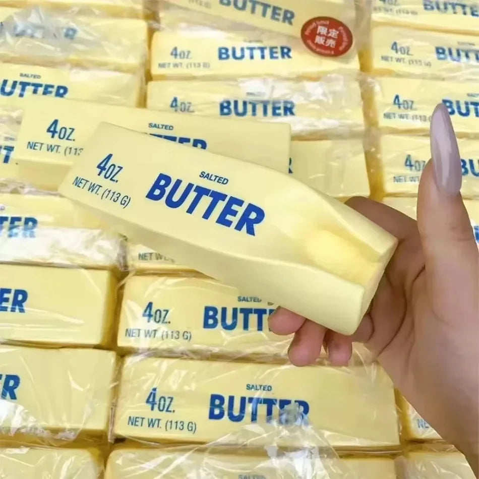 Squishy butter stick toy labeled SALTED BUTTER 4oz, held for squeezing