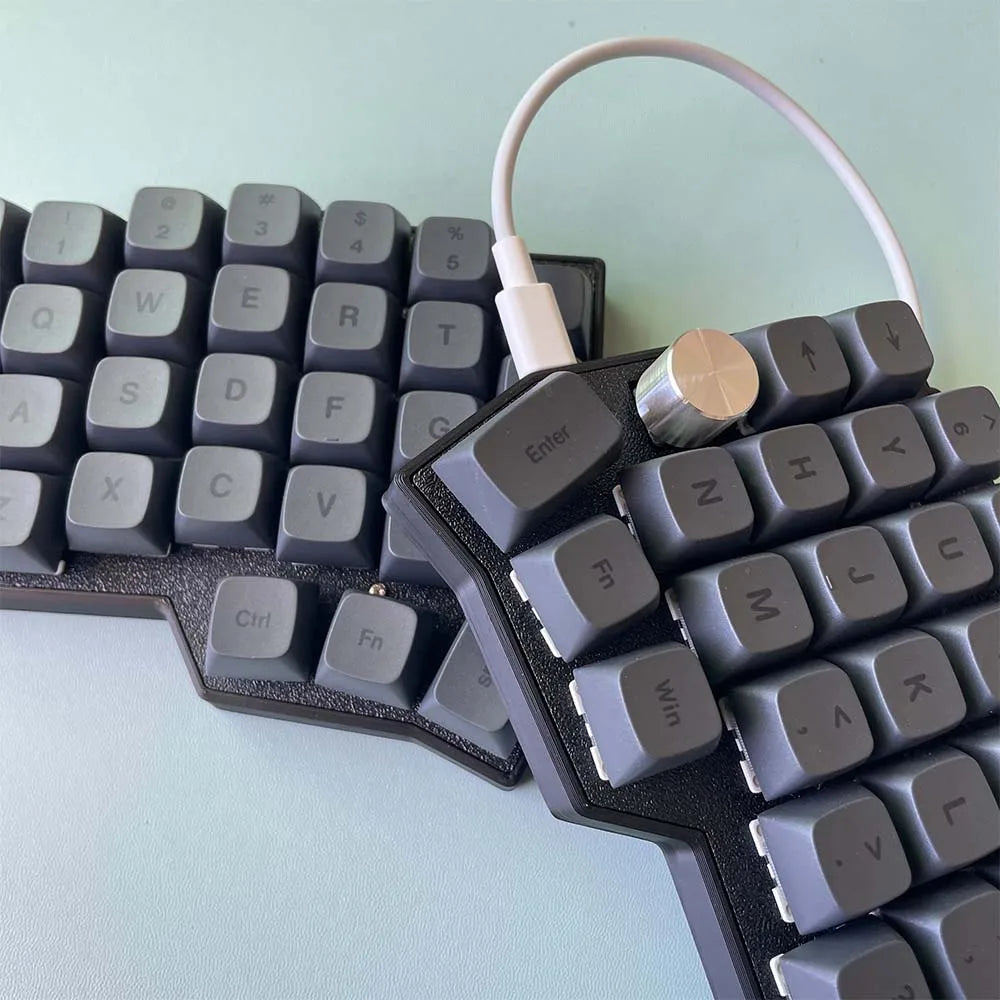 Close-up of Corne 4x6 split keyboard keycaps with rotary knob and connected cable