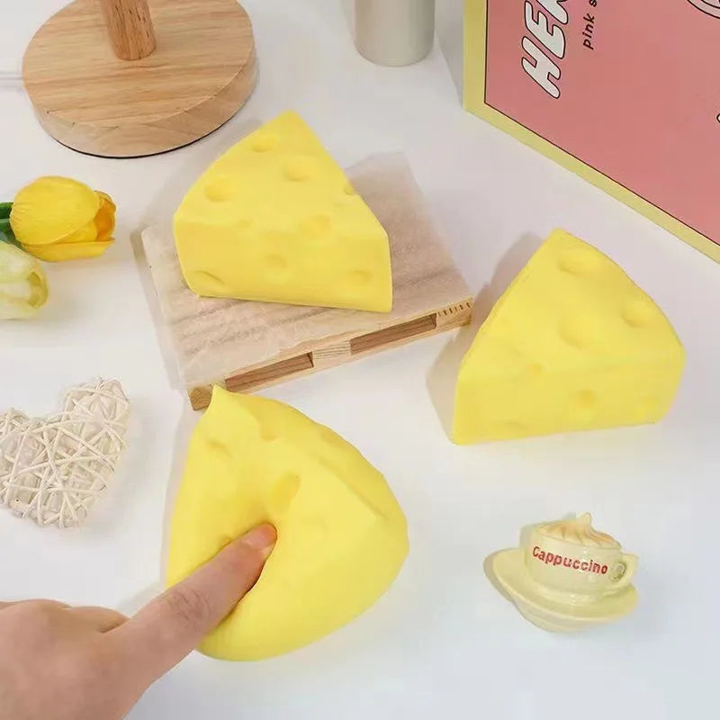 Set of yellow triangular cheese squishy toys with a hand pressing one