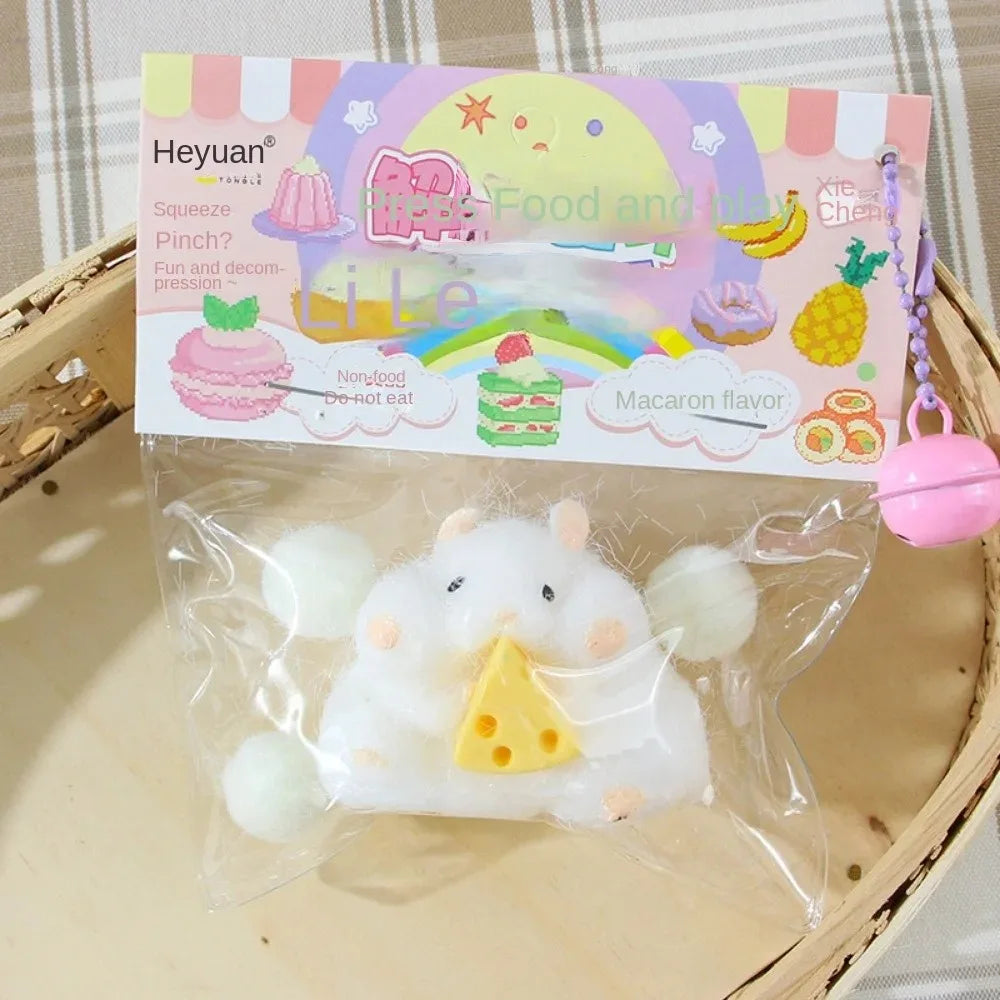 White squishy hamster plush toy in clear bag, holding a yellow cheese slice