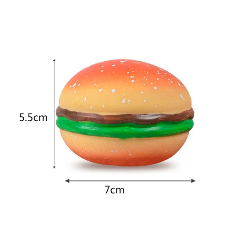 Squishy hamburger toy with orange bun, green filling, brown patty, and white sprinkles.